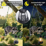 Solar Lighted Garden Outdoor Statue, 20.1" H Hanging Swing Lying with A Sleeping Raccoon and A LED Lantern, Resin | Lumora